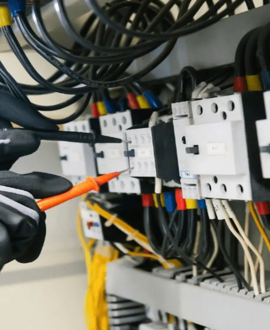 Electrician testing a board with a multimeter